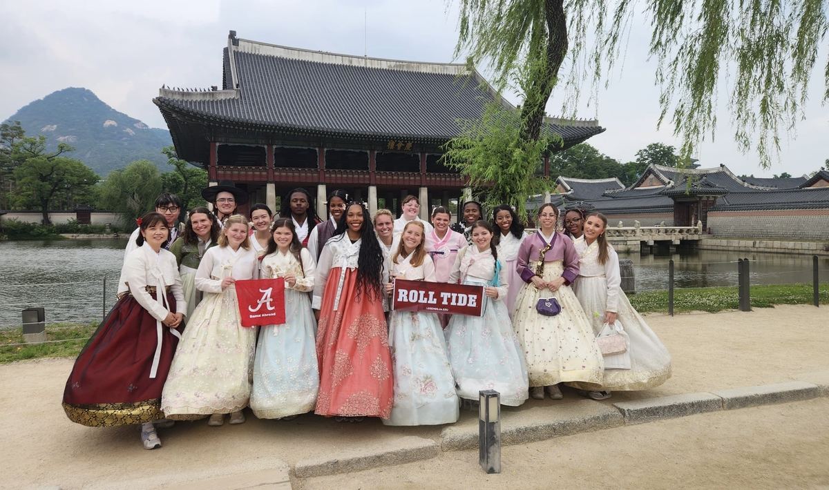 Students in hanbok in front of a palace pavilion in Seoul