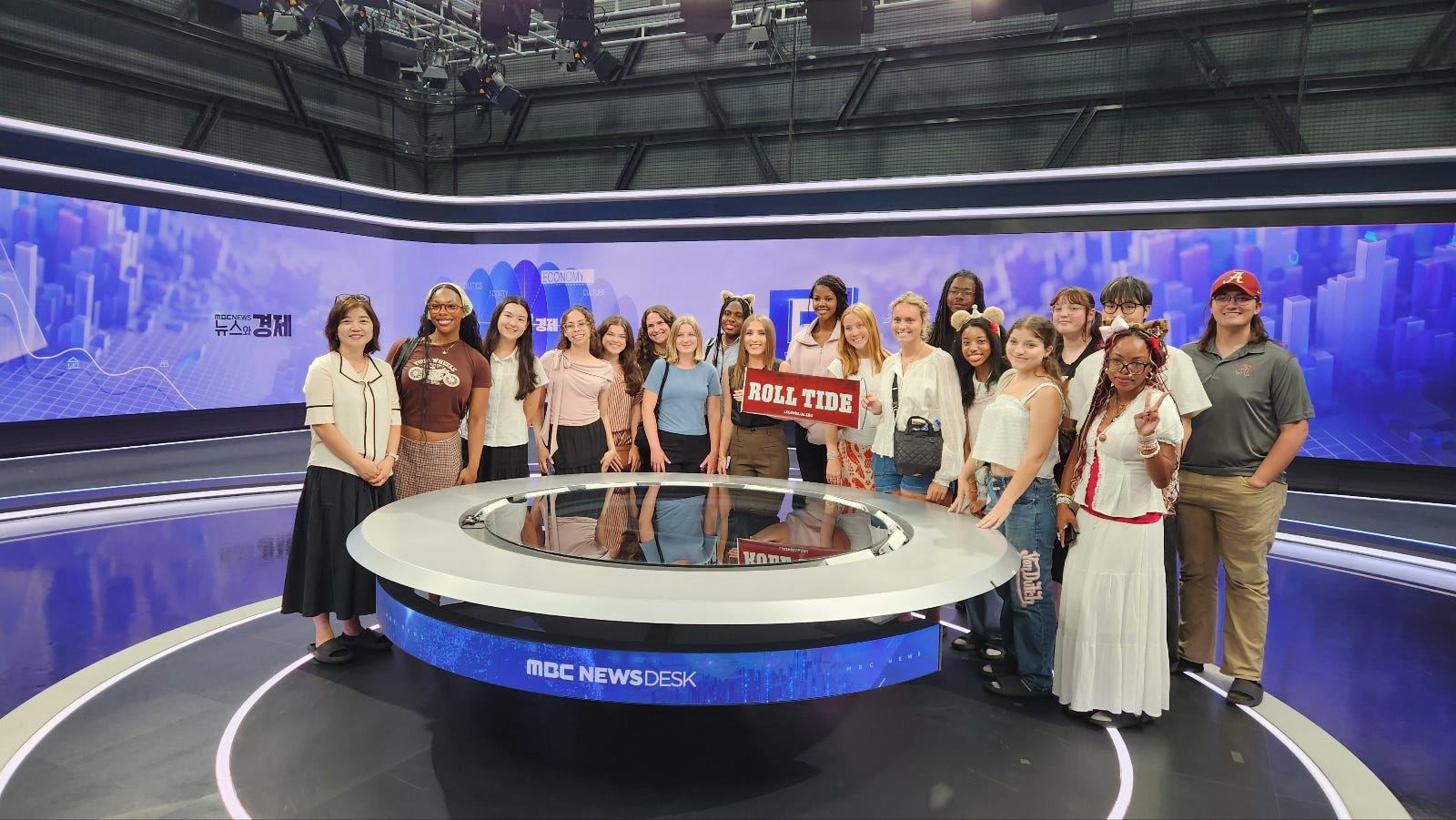 UA students standing on the MBC Newsdesk anchor set in Seoul